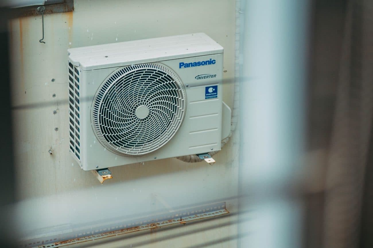 Outdoor air conditioner condenser unit mounted at a residence