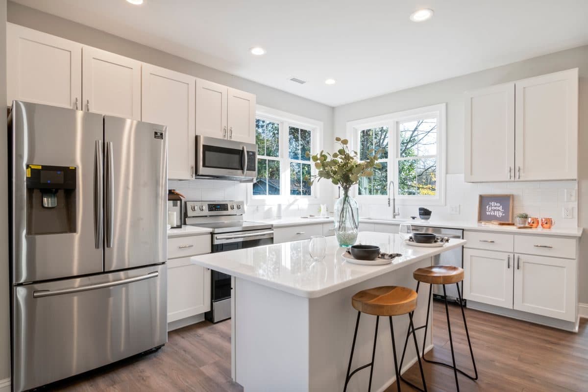 Newly remodeled kitchen with white cabinets, an island, and stainless appliances