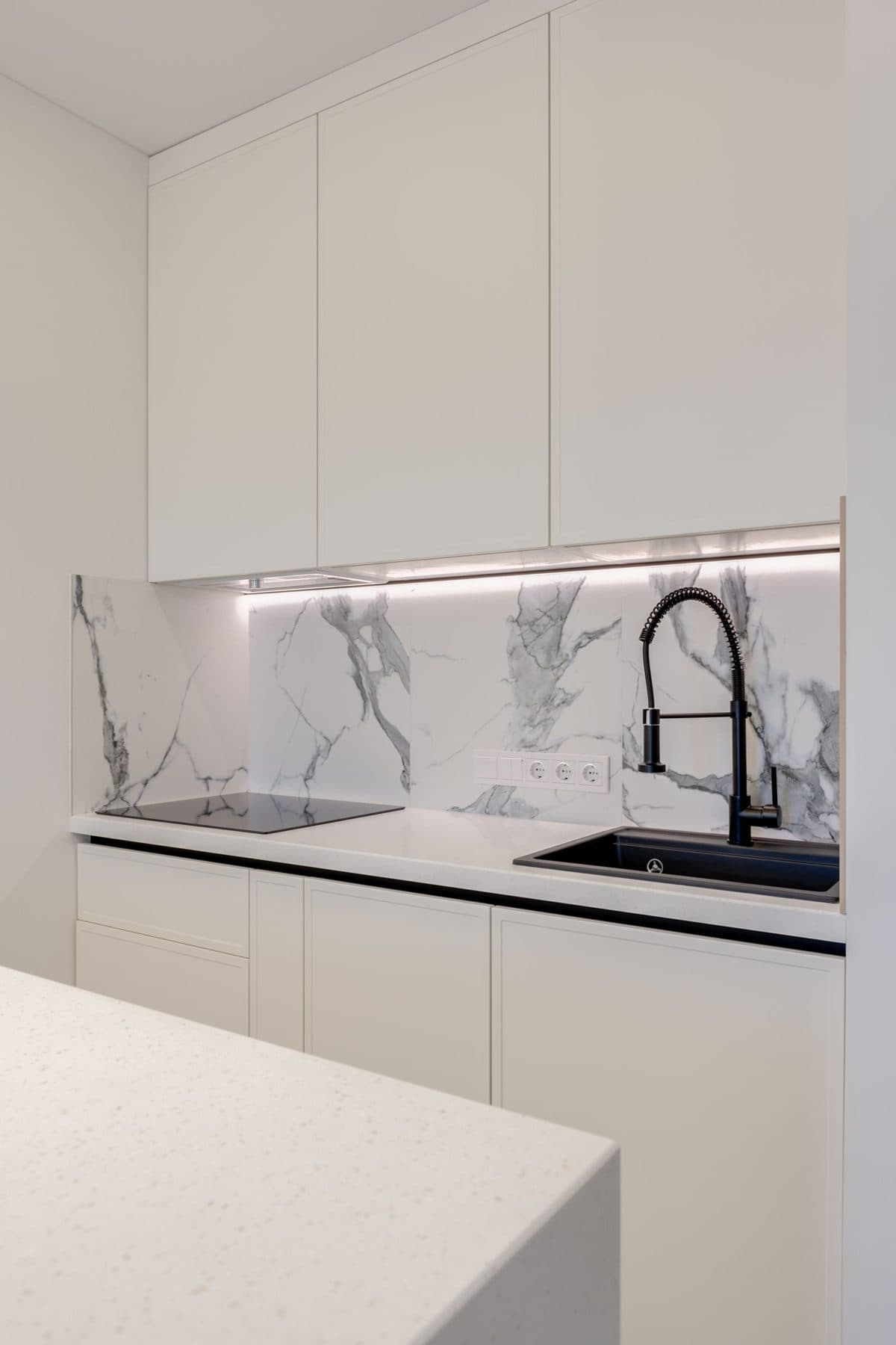 Modern kitchen counter with a marble backsplash and new cabinetry