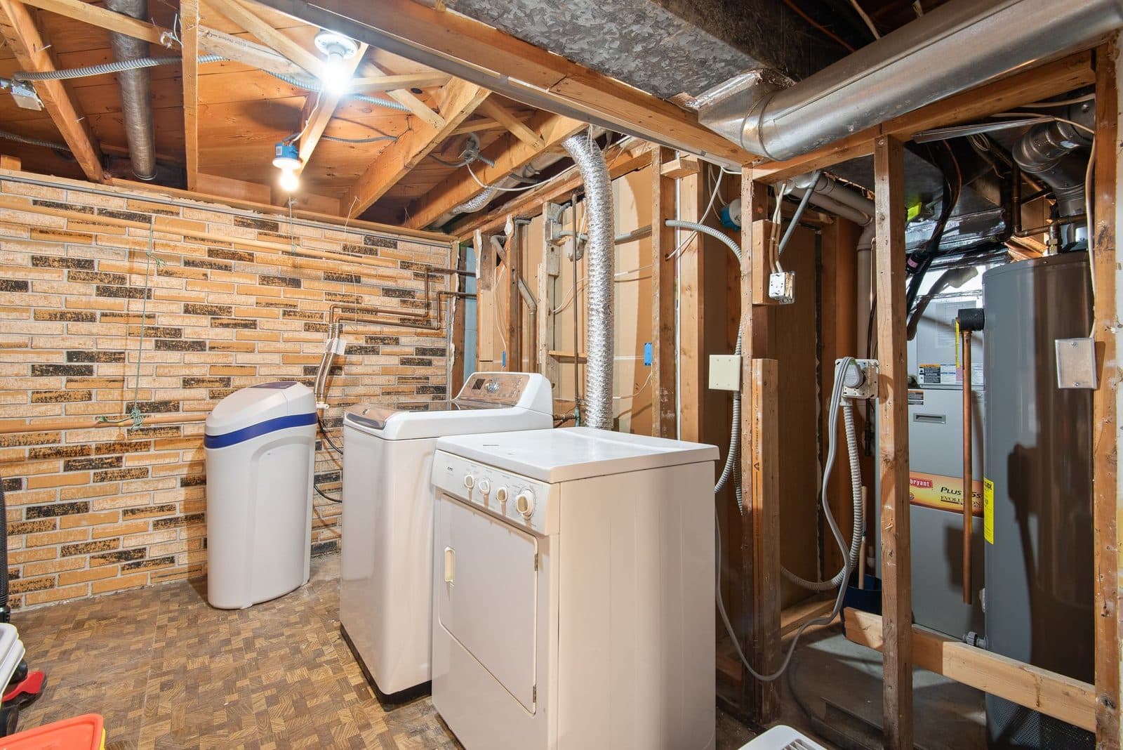 Basement utility room with a water heater, furnace, water softener, washer and dryer