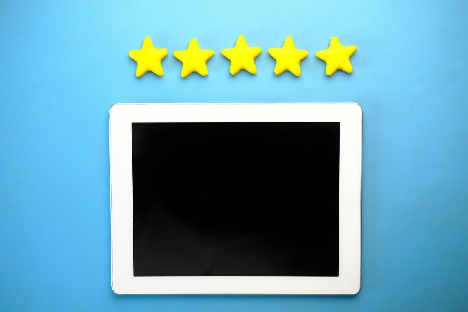 Five yellow stars arranged above a blank tablet screen on a blue background